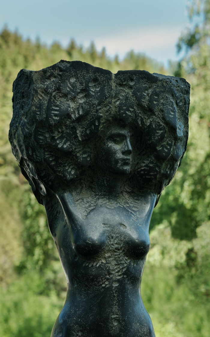 Statue of a woman. Torso. Big hair.